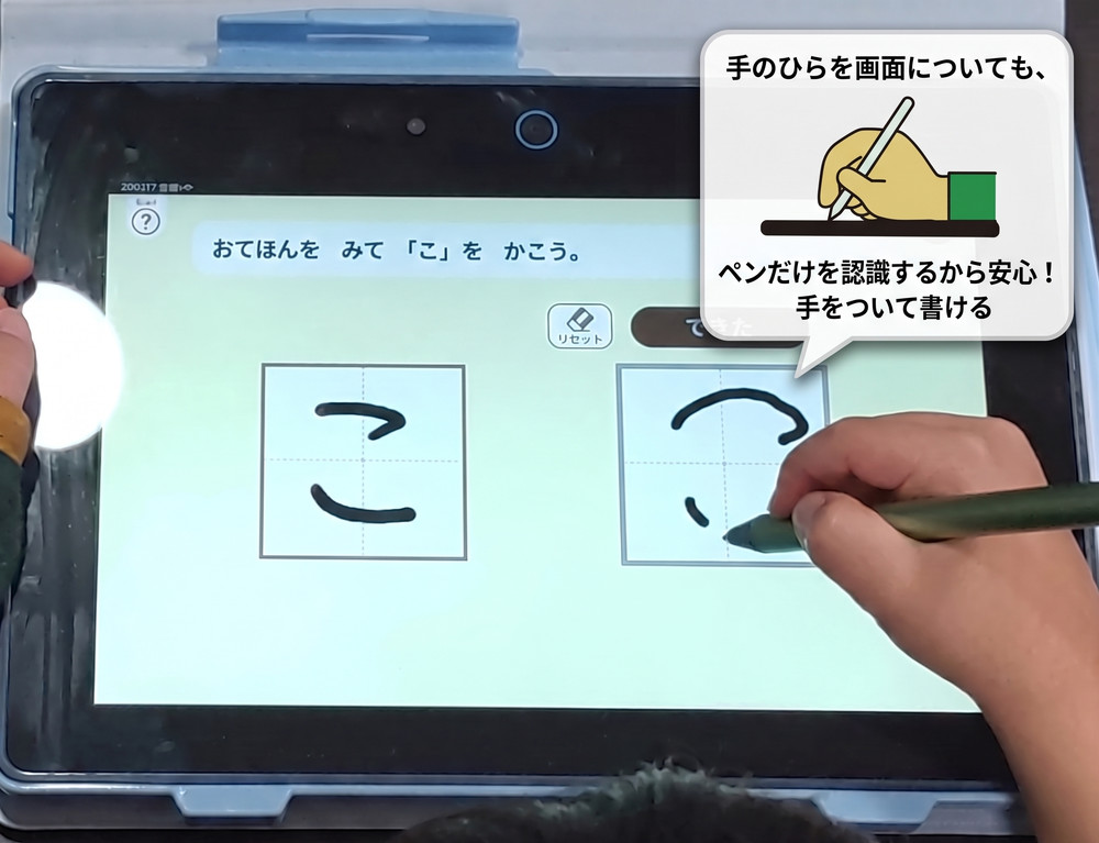 こどもちゃれんじの専用タブレット〈チャレンジパッド〉で平仮名の「こ」の字をタブレットに手をついたまま書いている